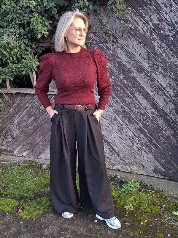 Losse zwarte broek met riem en elastiek aan de achterkant